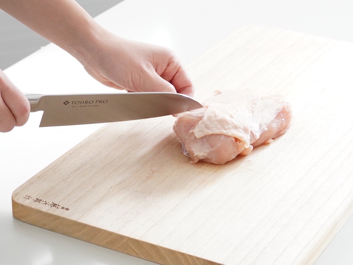 三徳包丁で鶏肉を切る 鋭い切っ先で筋をきるのも得意