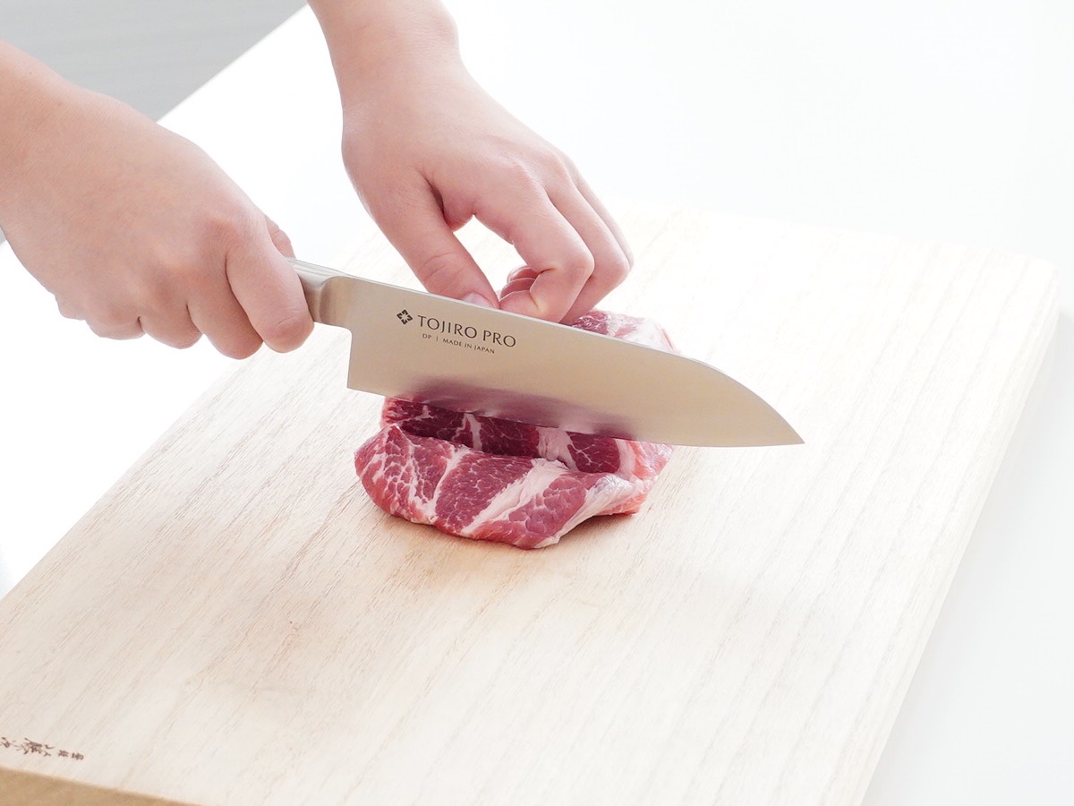三徳包丁で豚肉を切る